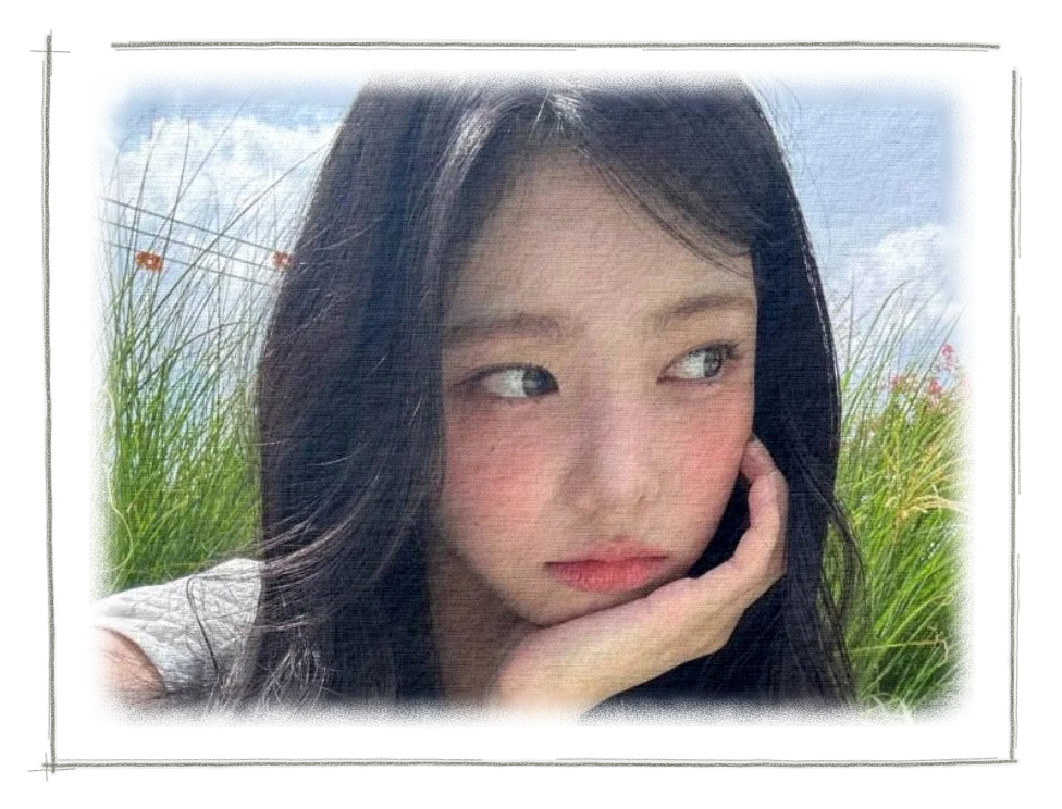 Ian resting her cheek on her hand outdoors, with green grasses and blue sky behind her